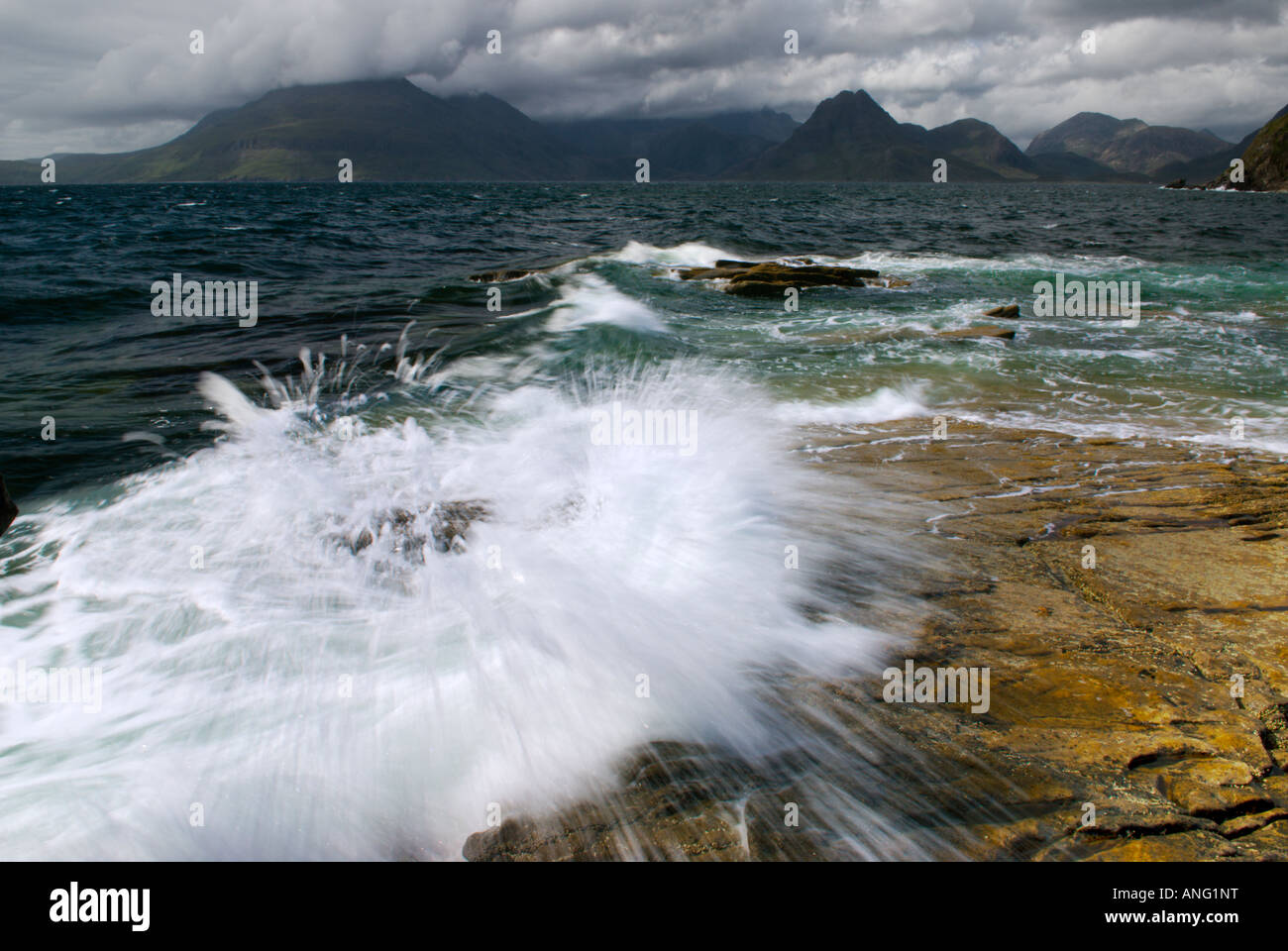 Waves Sea Surf Breaking On The Shoreline The Cuilin Mountains In Distance, Elgol Beach The 'Isle Of Skye' Scotland UK Stock Photo
