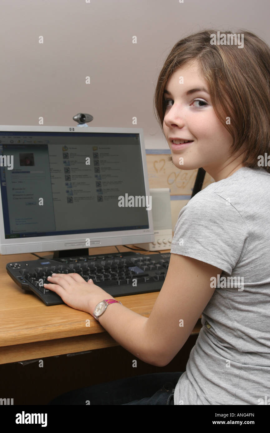 A thirteen year old girl working on her home PC Stock Photo