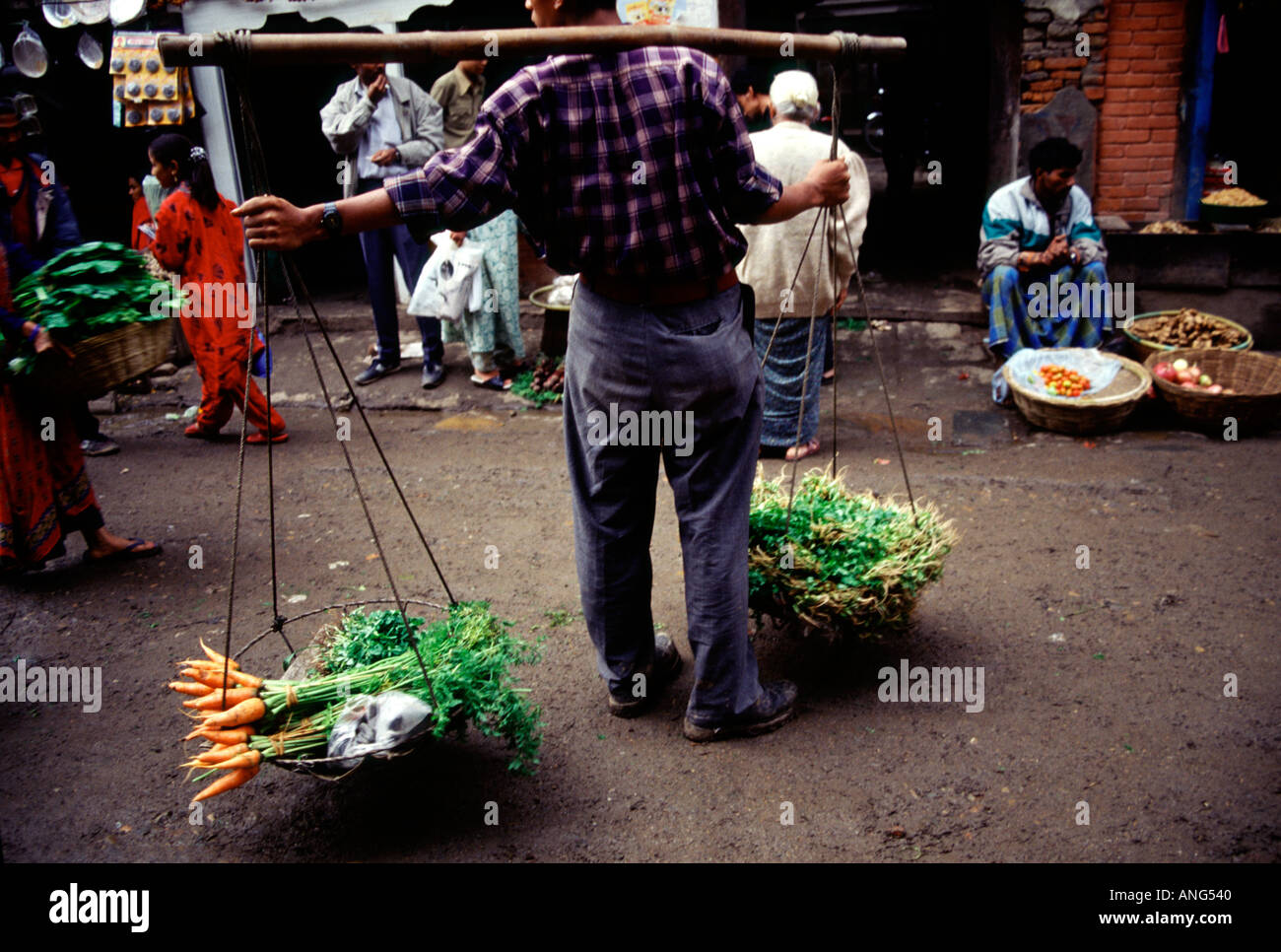 A man of the Newar tribe of Nepal carrying vegetables through the streets of Kathmandu Nepal Stock Photo