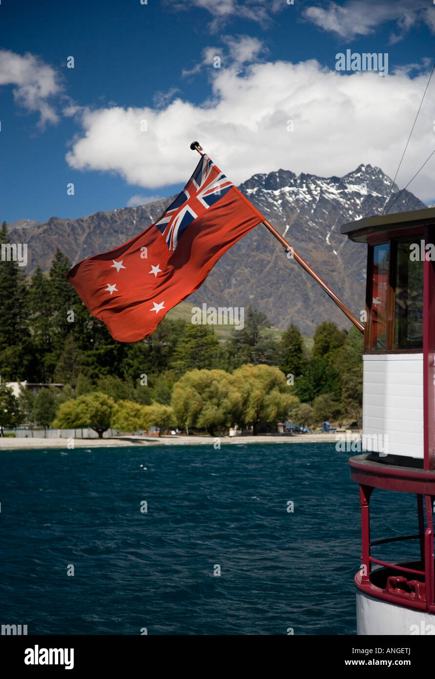 A flag on the stern of the T.S.S. Earnslaw with The Remarkables in the background Stock Photo