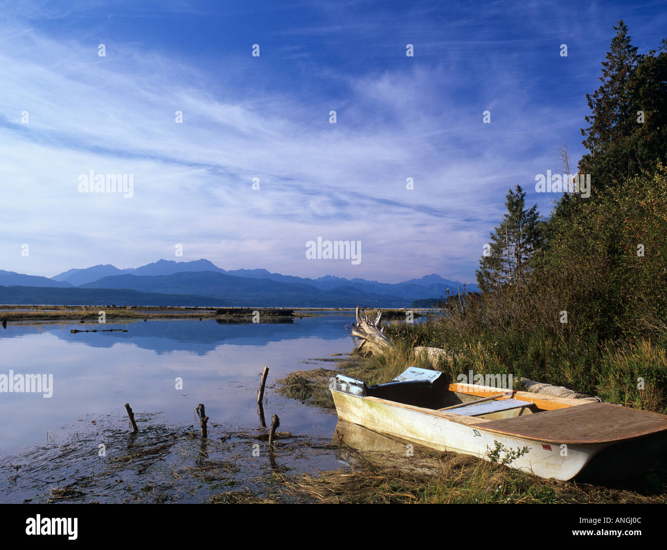 SMALL WOODEN FISHING BOAT on shore of the Hood Canal near Union, Washington State, United States of America Stock Photo