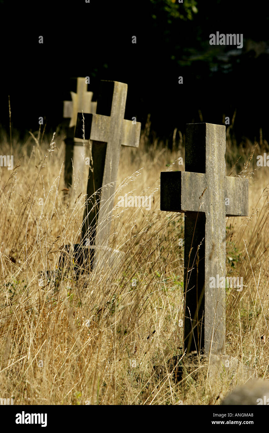 cross grave stones in overgrown summer grass Stock Photo