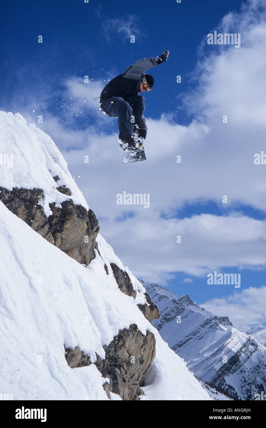 Young male snowboarder flying off cliff at Lake Louise, Banff National