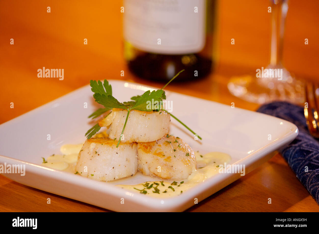 Seared Scallops with Hollandaise sauce served with a glass of white