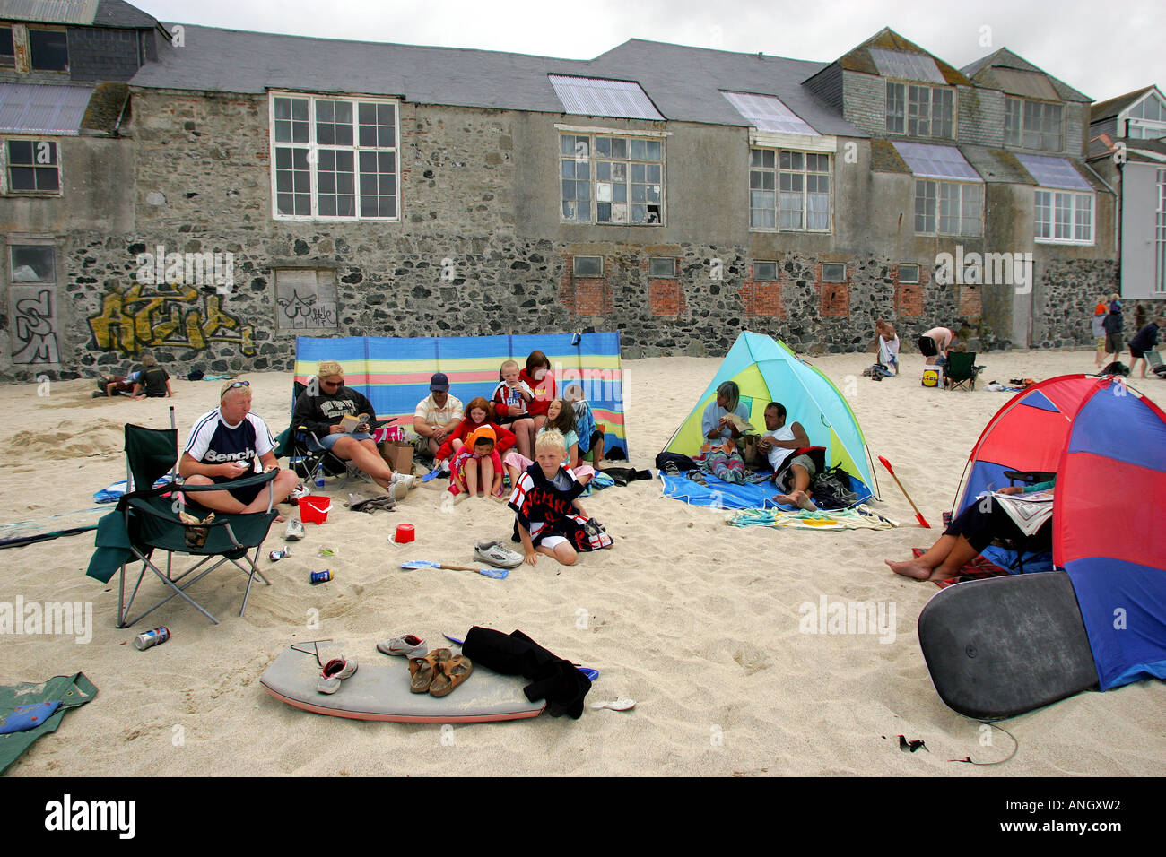 Holidaymakers on the beach in front of artists studios on Porthmeor Beach, St Ives, Cornwall, England, UK Stock Photo