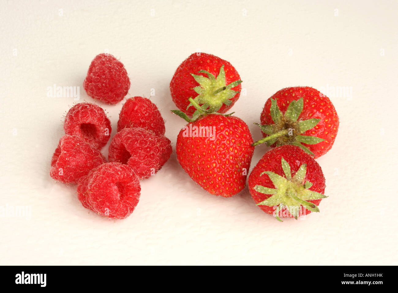 A cutout shot of strawberries and raspberries against a white background Stock Photo