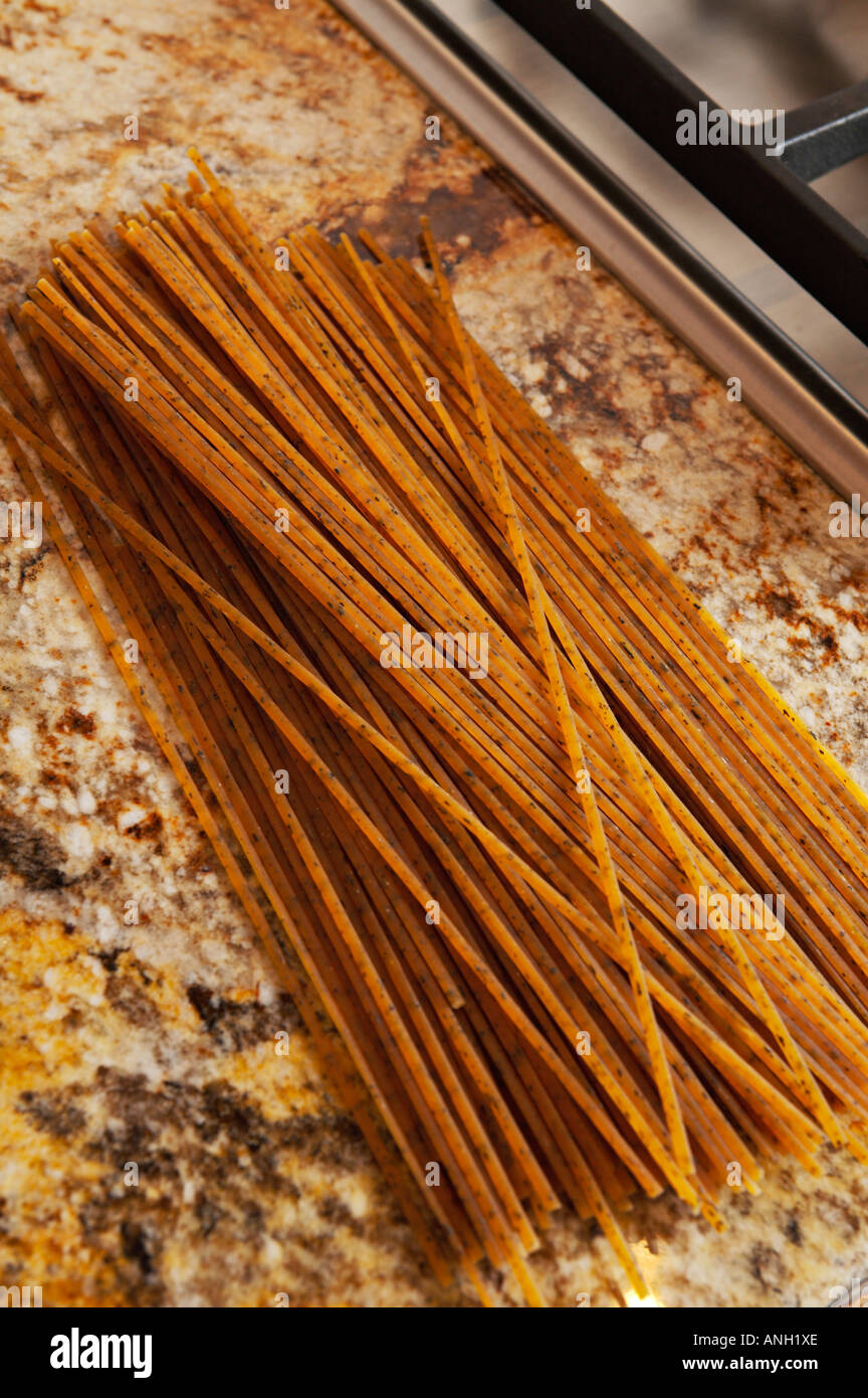 STILL LIFE Riverwoods Illinois Strands of dried pasta on granite counter top next to stove Stock Photo