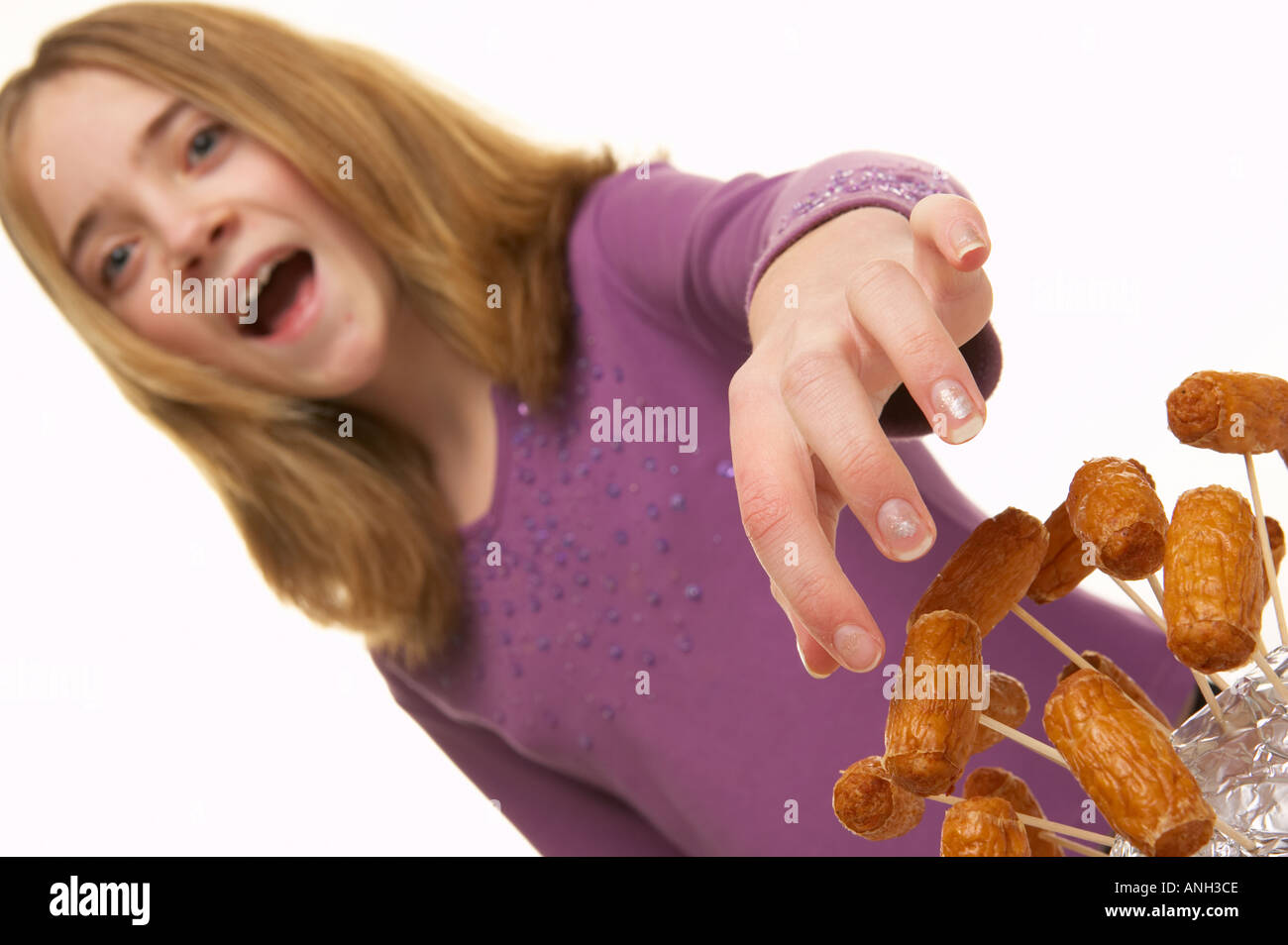 Young white girl picking cocktail sausage party food Stock Photo