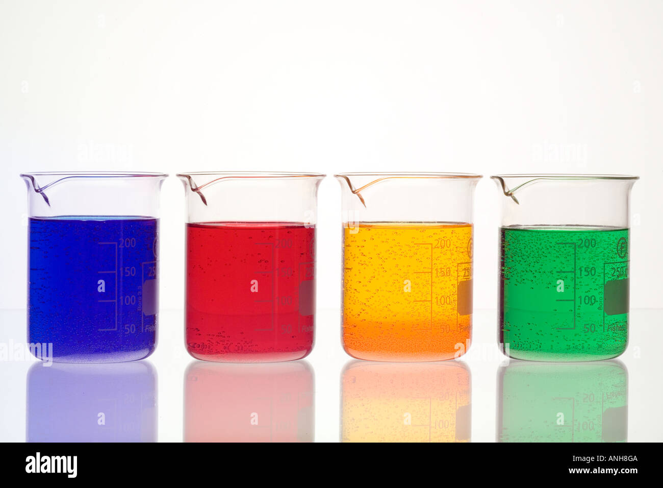 4 four beaker chemical beakers with coloured liquids Stock Photo