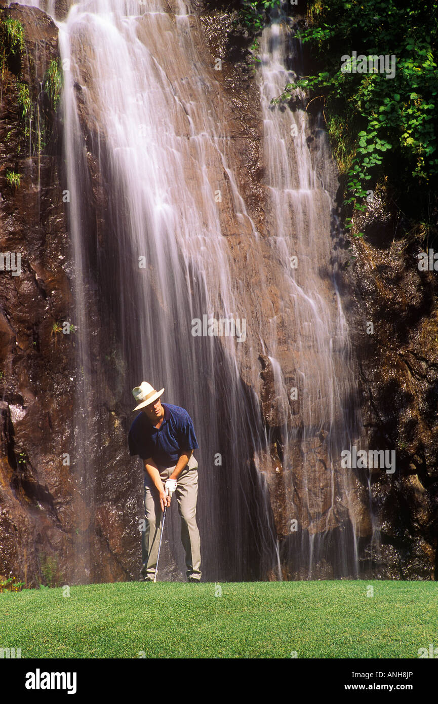 Golfer putting in front of Waterfall, Olympic View golf course, British Columbia, Canada. Stock Photo