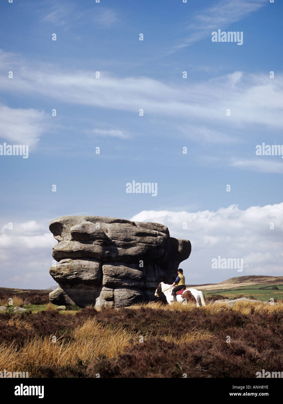 Horse and Rider by Eagle stone rock gritstone monolith on Eaglestone Flat in Peak District 'National Park' Derbyshire England U Stock Photo