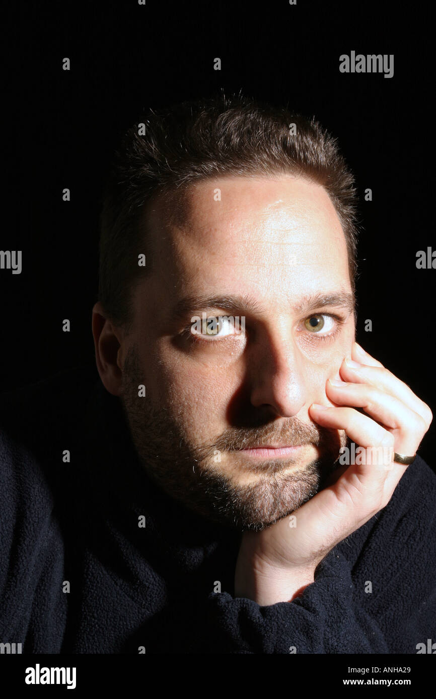 Man in thoughtful pose with hand resting on face Stock Photo Alamy