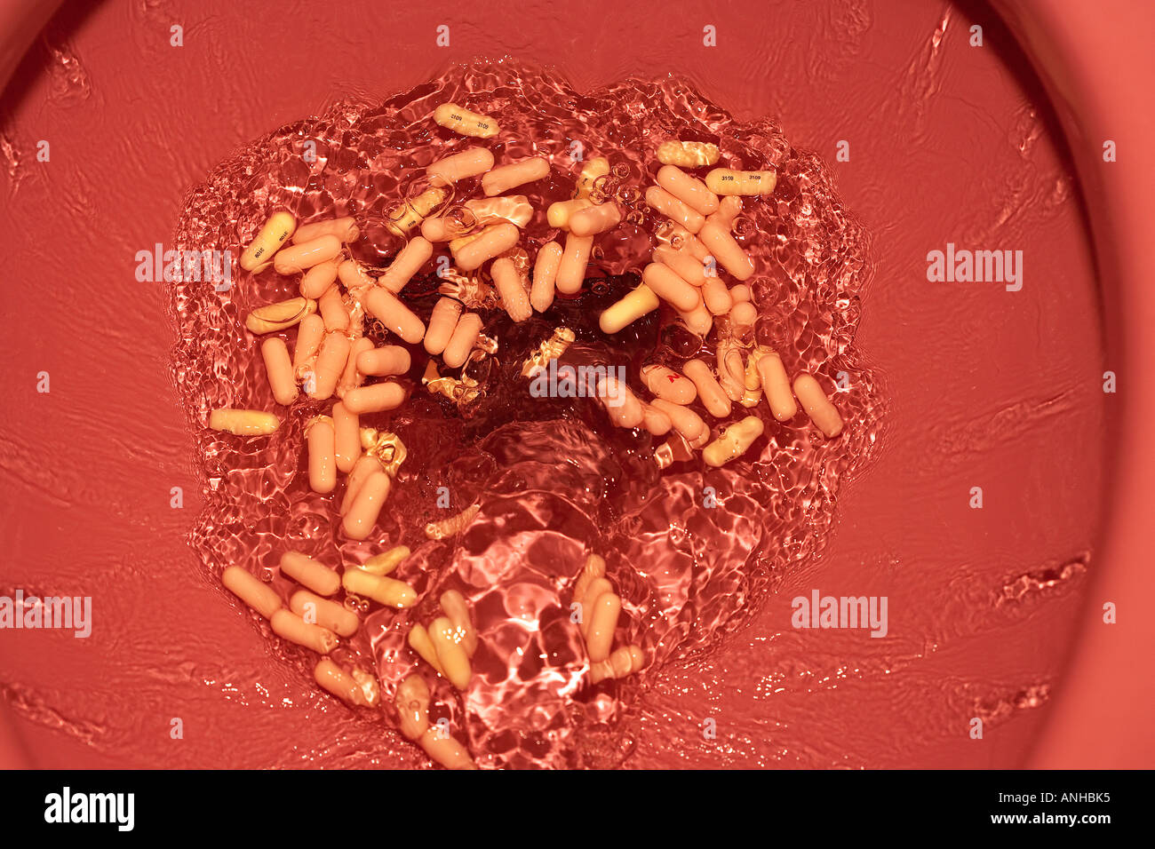 Pills Being Flushed down a Toilet Stock Photo