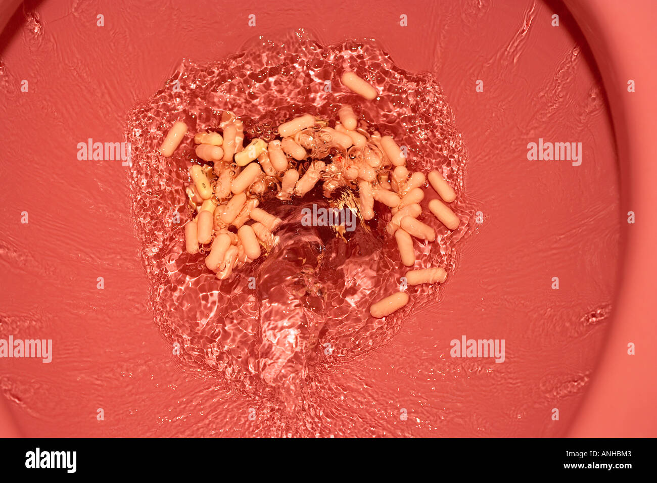 Pills Being Flushed down a Toilet Stock Photo