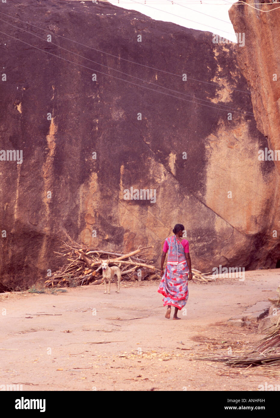 Indian woman sari by large rock, India Stock Photo - Alamy