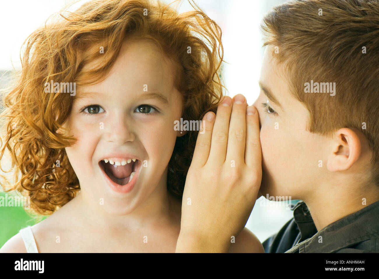 Boy whispering in girl's ear, close-up Stock Photo