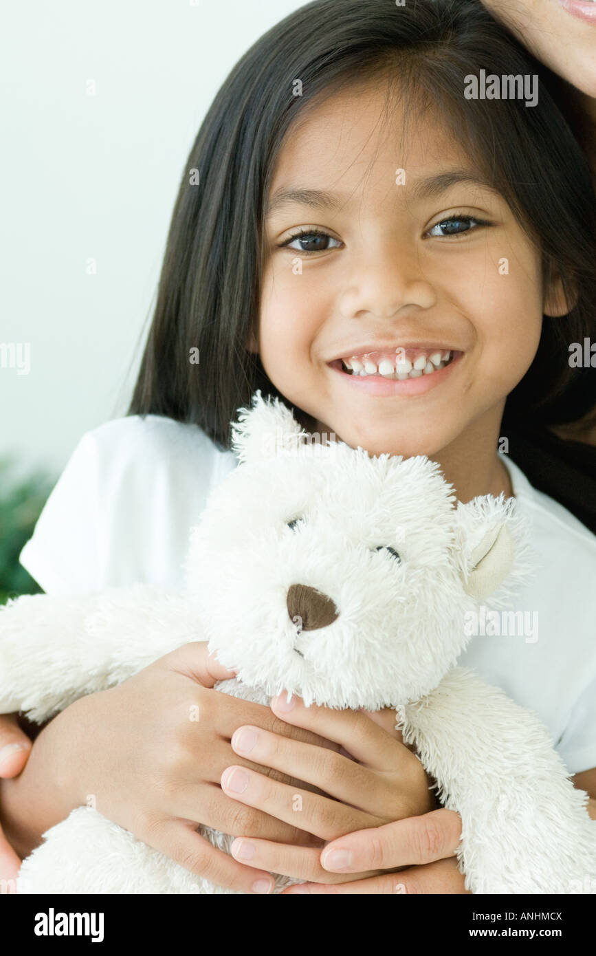 Girl holding teddy bear, smiling at camera Stock Photo - Alamy