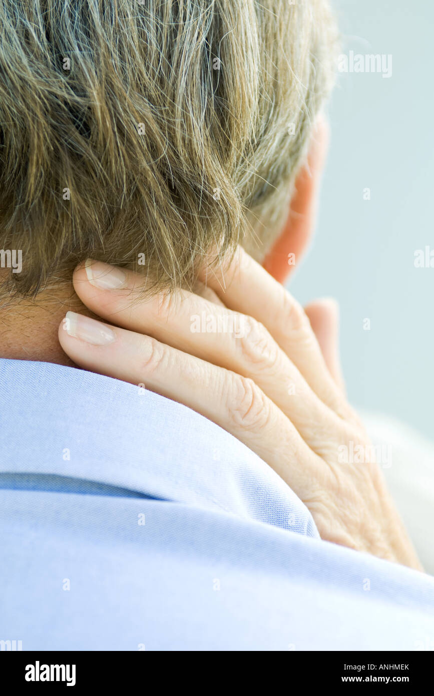 Cropped rear view of hand touching man's neck Stock Photo