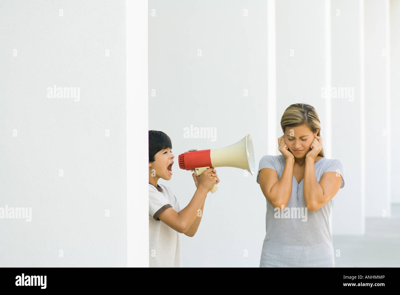 Boy screaming at mother through megaphone Stock Photo