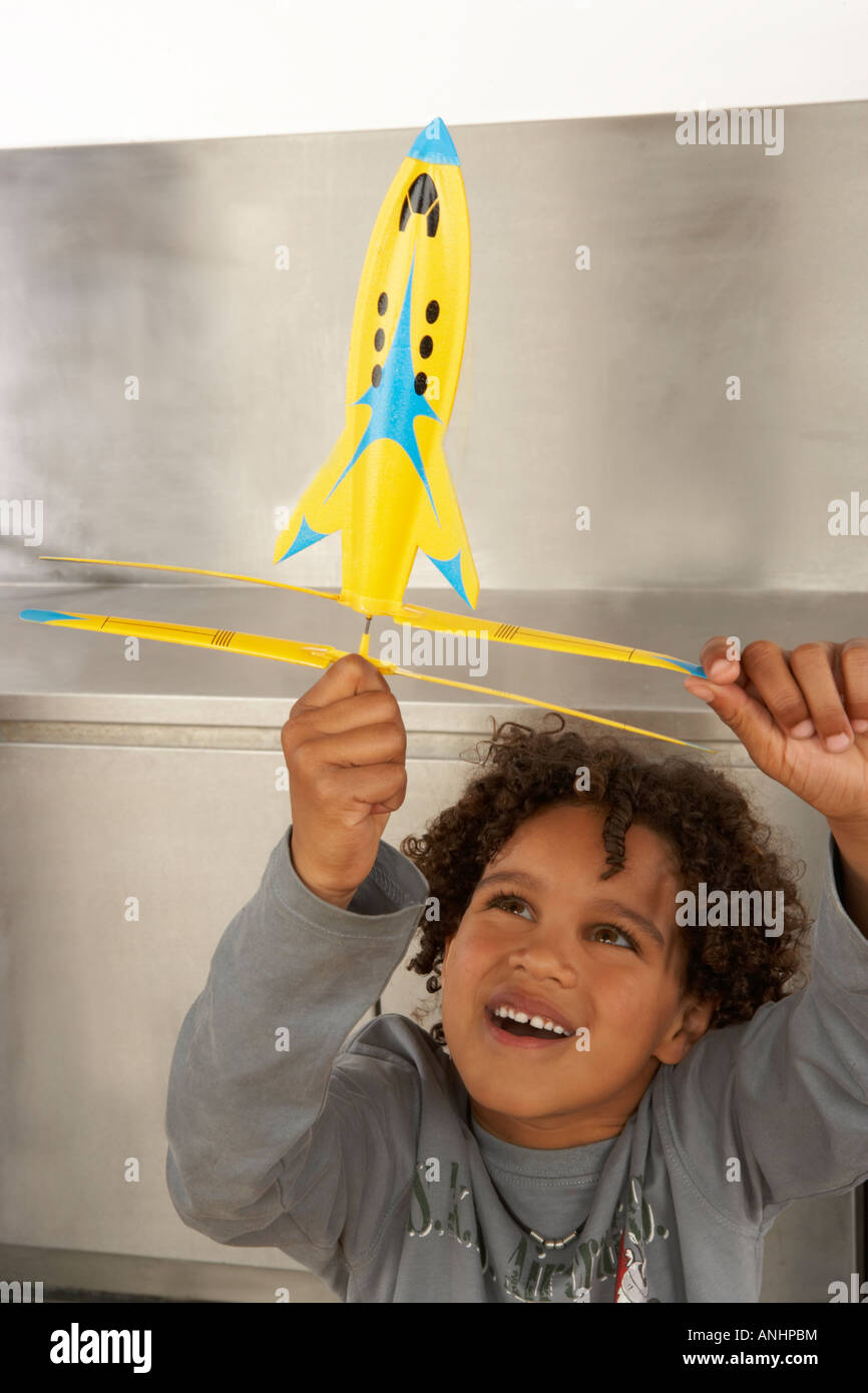 a boy smiles as he plays with a toy rocket Stock Photo - Alamy