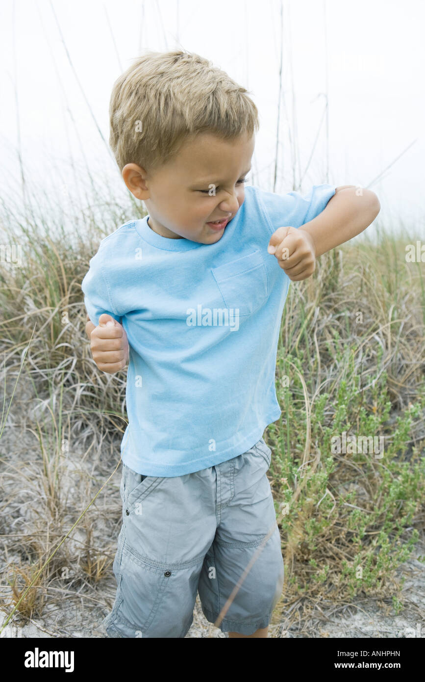 Young boy holding up elbow, wrinkling nose Stock Photo Alamy