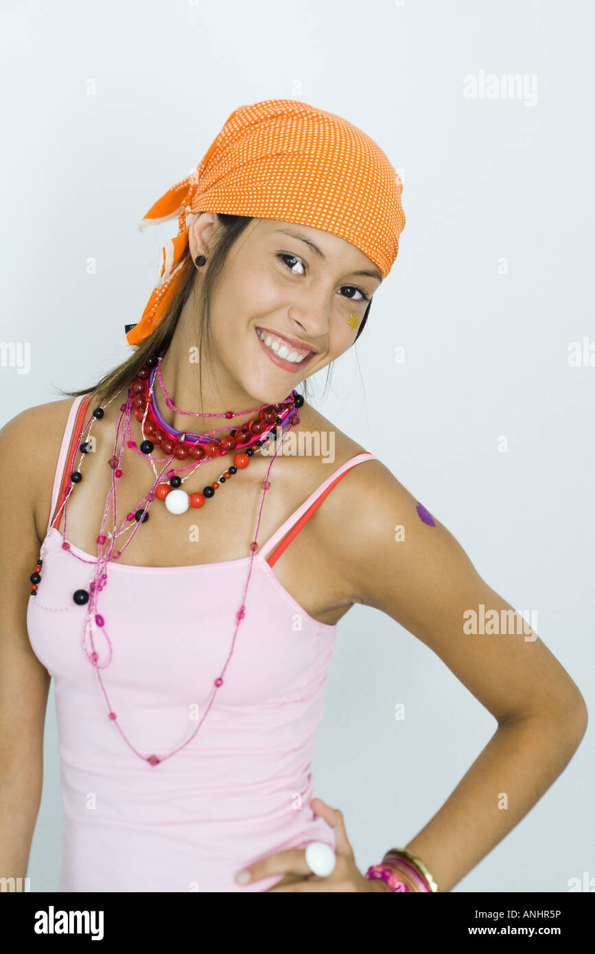 Teenage girl wearing bandana, smiling over shoulder at camera, hand on