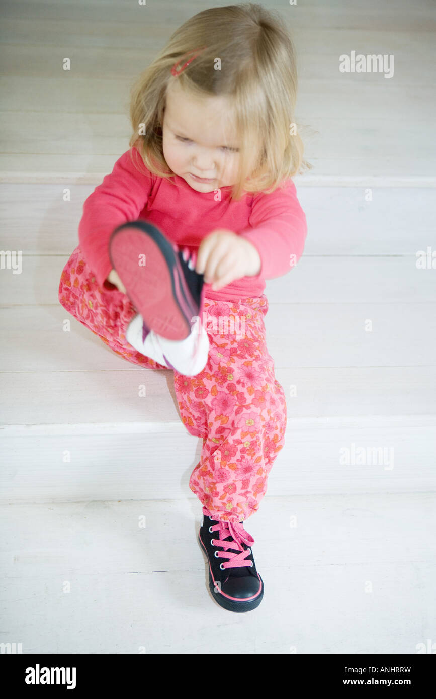Little girl putting on shoes hires stock photography and images Alamy