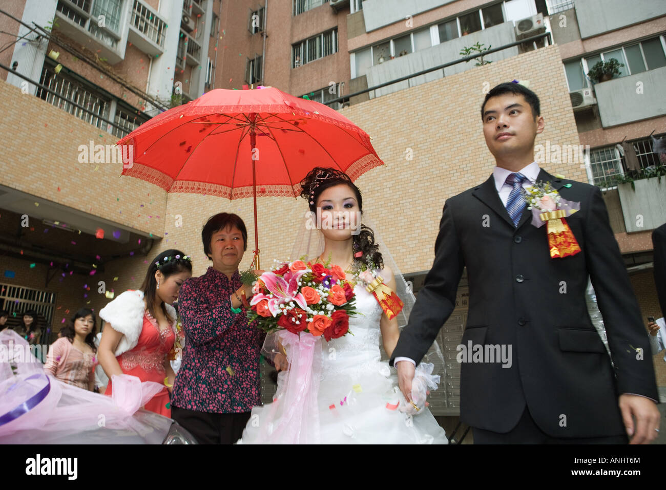 Chinese wedding, bride and groom leaving under confetti, bride covered
