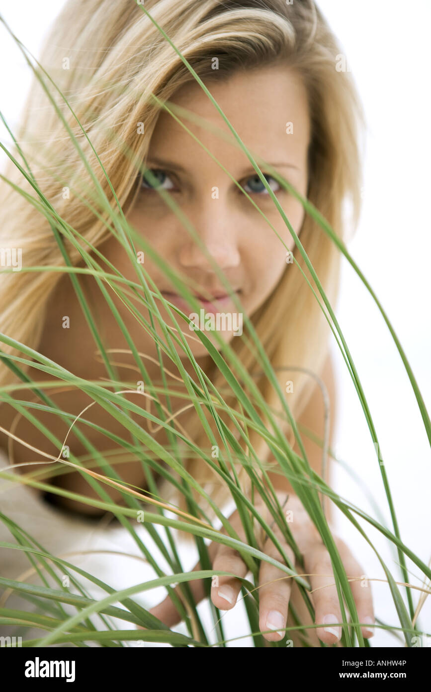 Woman looking through tall grass Stock Photo