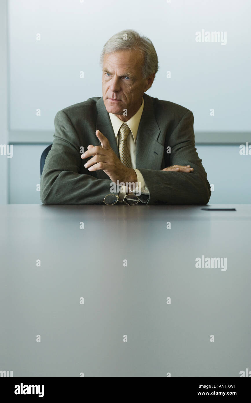 Businessman seated, furrowing brow and pointing finger Stock Photo