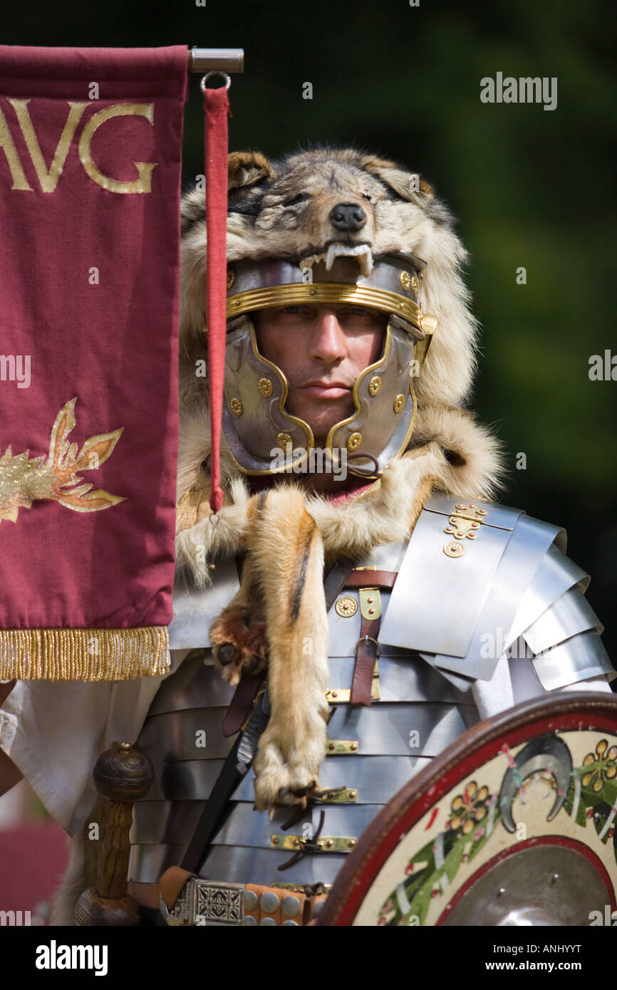 A reenactor dressed as a Roman Centurion and holding a legionnary standard, Chedworth, Gloucestershire, UK Stock Photo