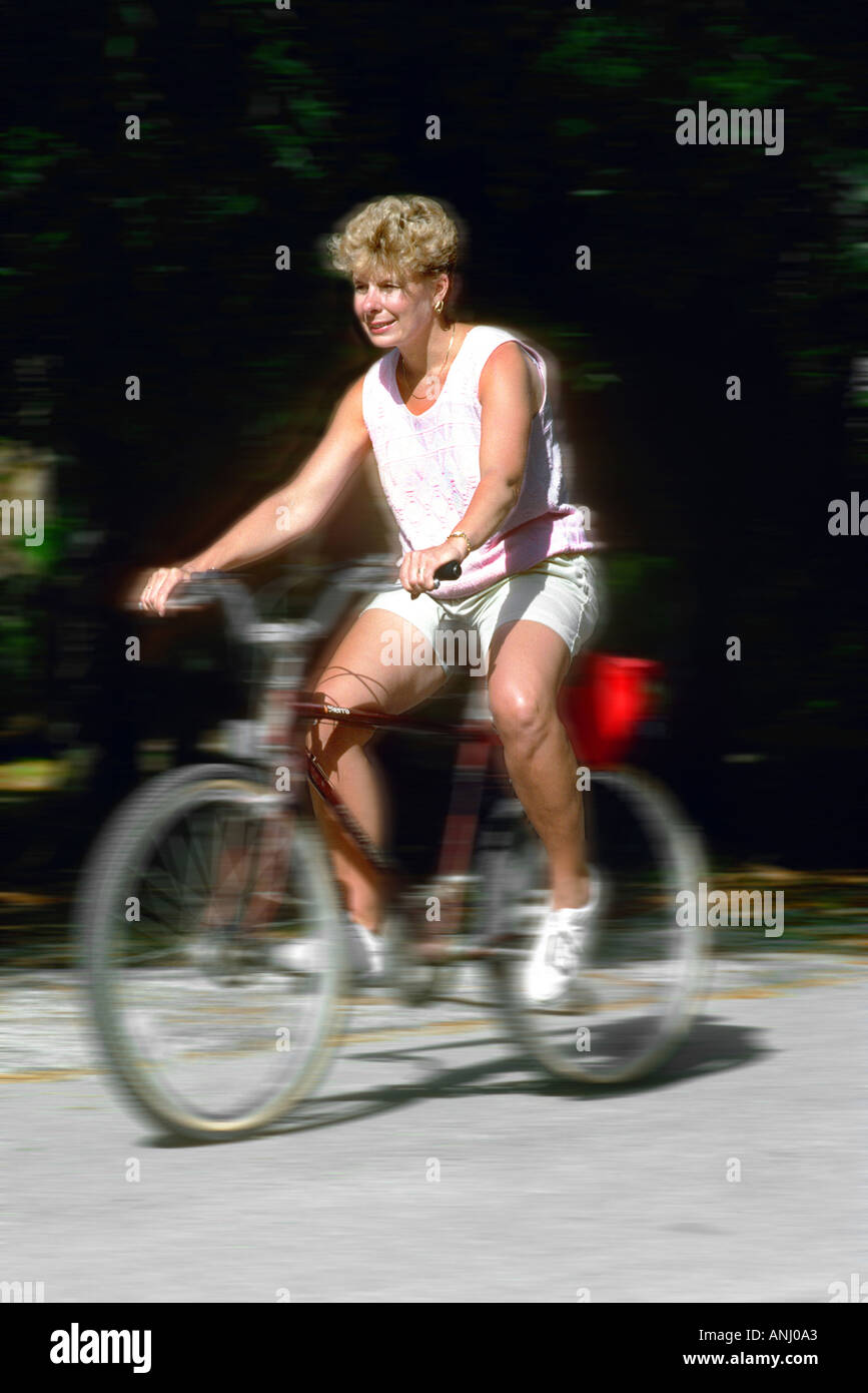Adult female rides on a bicycle for recreation and exercise Stock Photo ...
