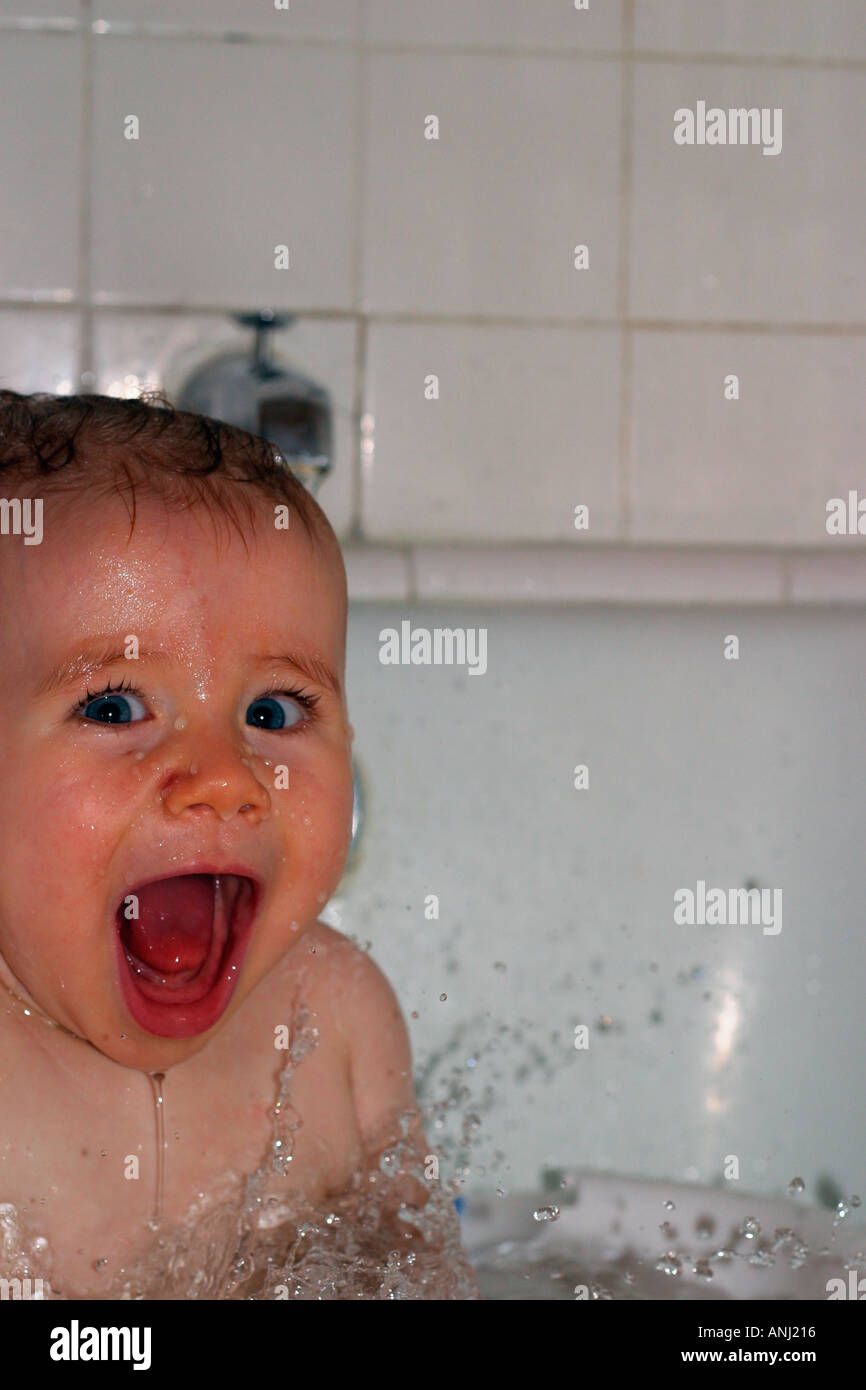 Happy baby takes a bath and laughs baby baby food bath tub vertical bathtub laugh mouth open teeth Model released and Proper Stock Photo