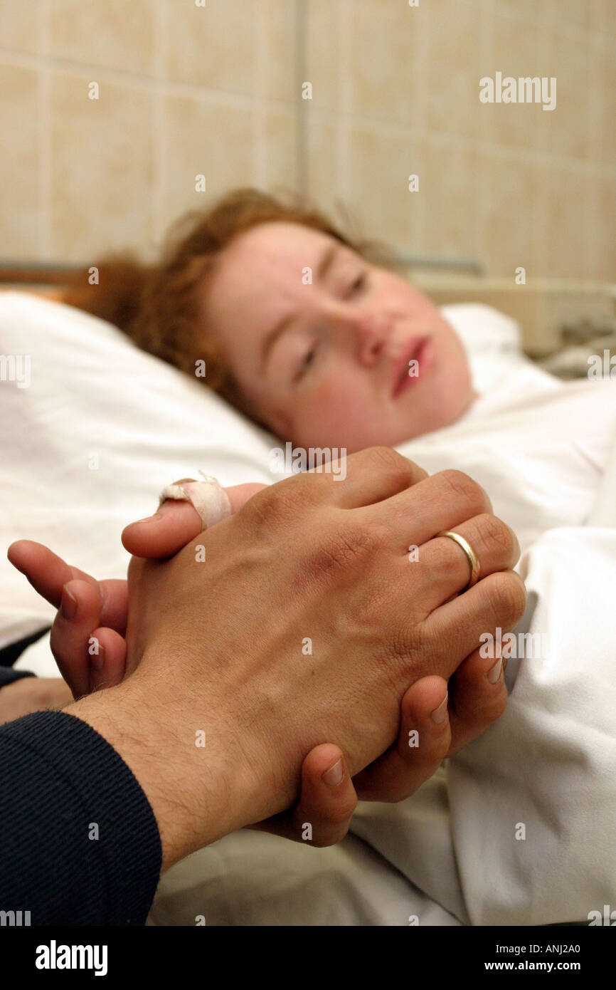 Husband holding the hand of his wife during the later stages of labour Stock Photo