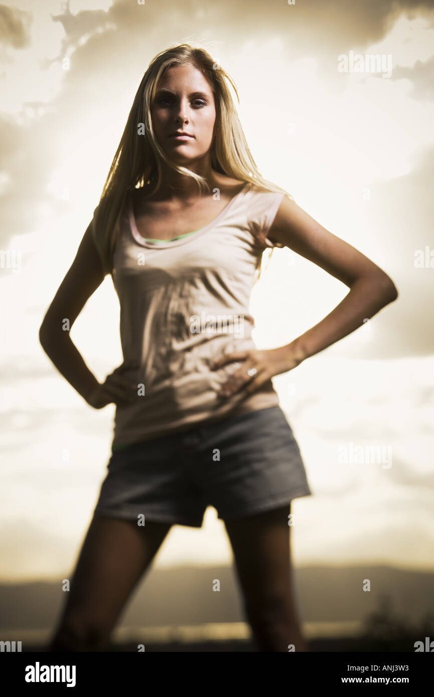Young woman standing with her hands on her hips Stock Photo - Alamy