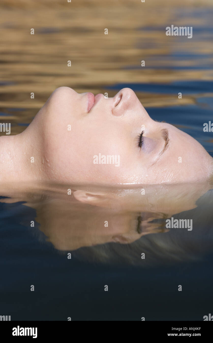 Profile of a young woman floating in water Stock Photo - Alamy