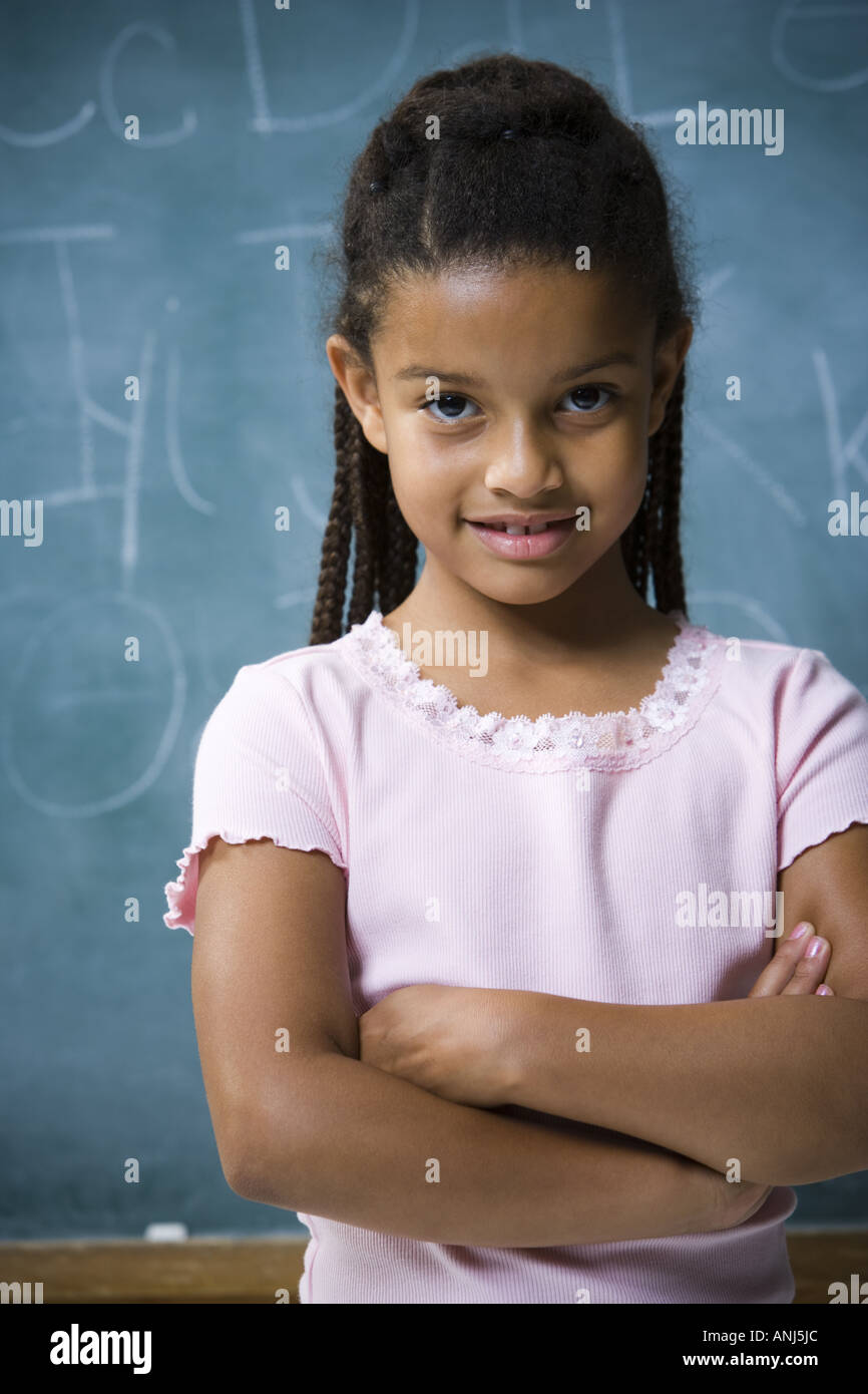 Portrait of a girl standing with her arms crossed and smiling Stock ...