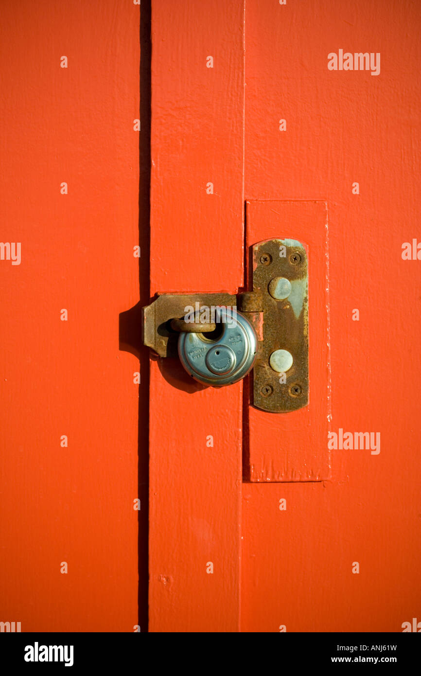 Padlock on orange wooden door Stock Photo