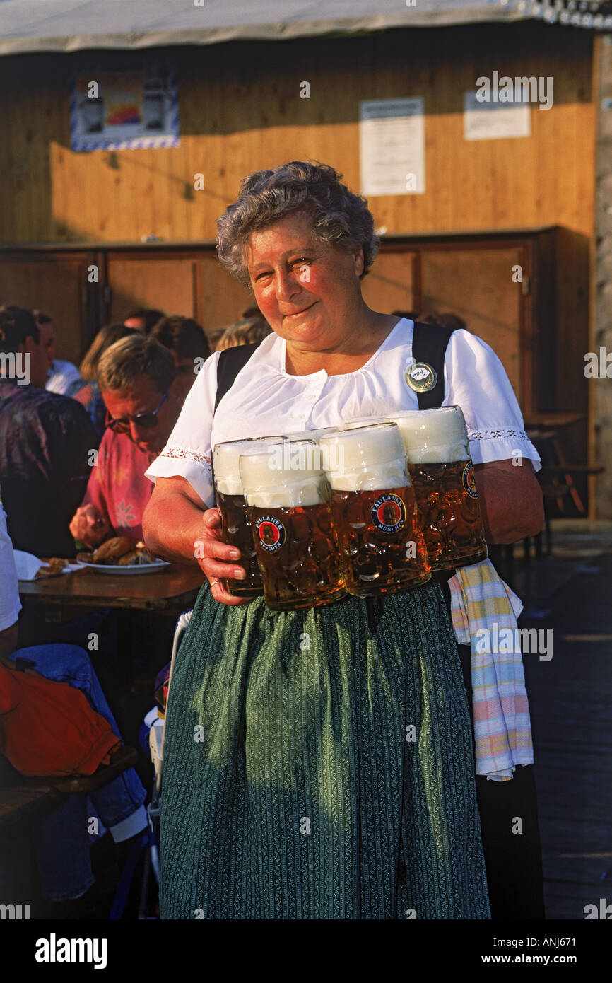 German waitress serving mugs of beer at October Festival in Munich Stock Photo