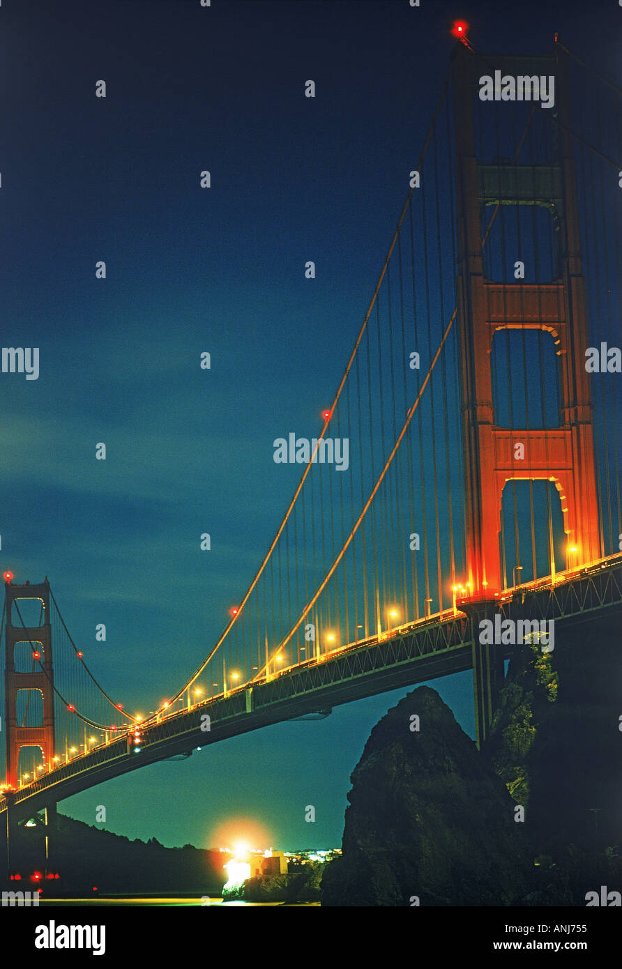 Lime Point Lighthouse under Golden Gate Bridge at night Stock Photo