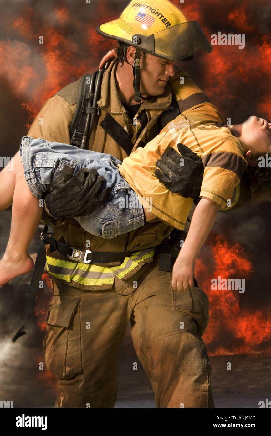 Firefighter carrying an injured boy Stock Photo