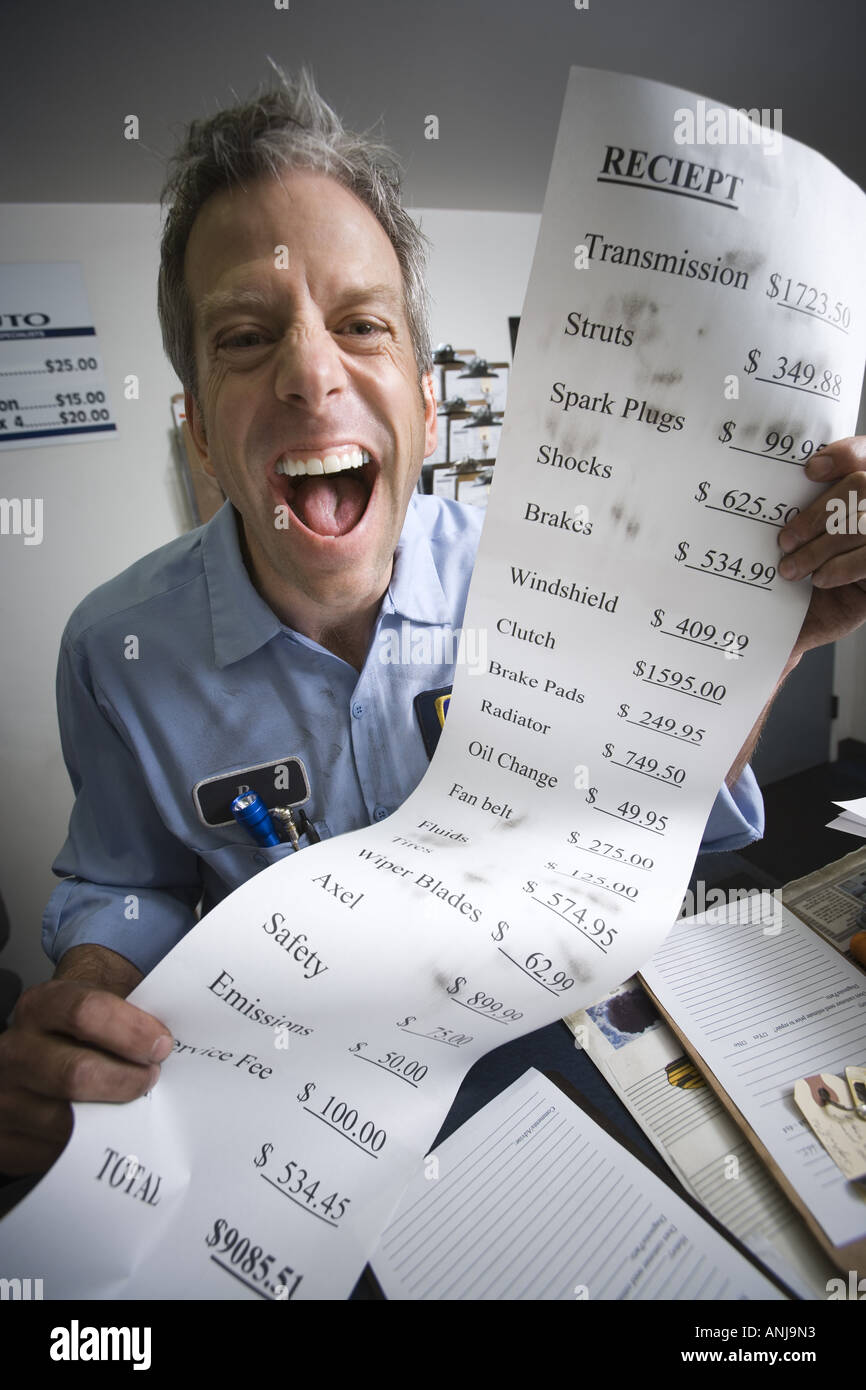 Portrait of a mechanic holding a bill Stock Photo
