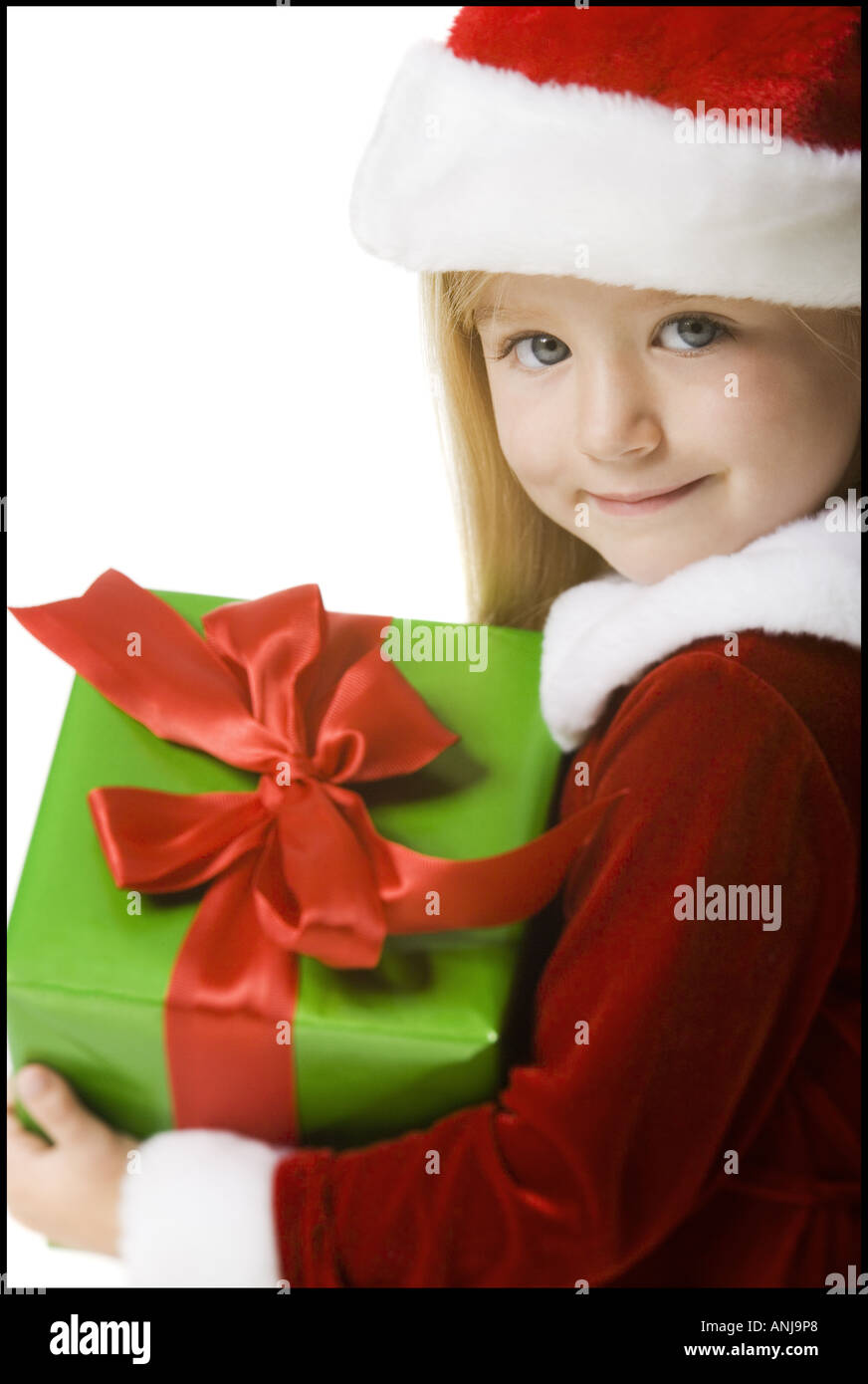 Portrait of a girl holding a Christmas present and smiling Stock Photo