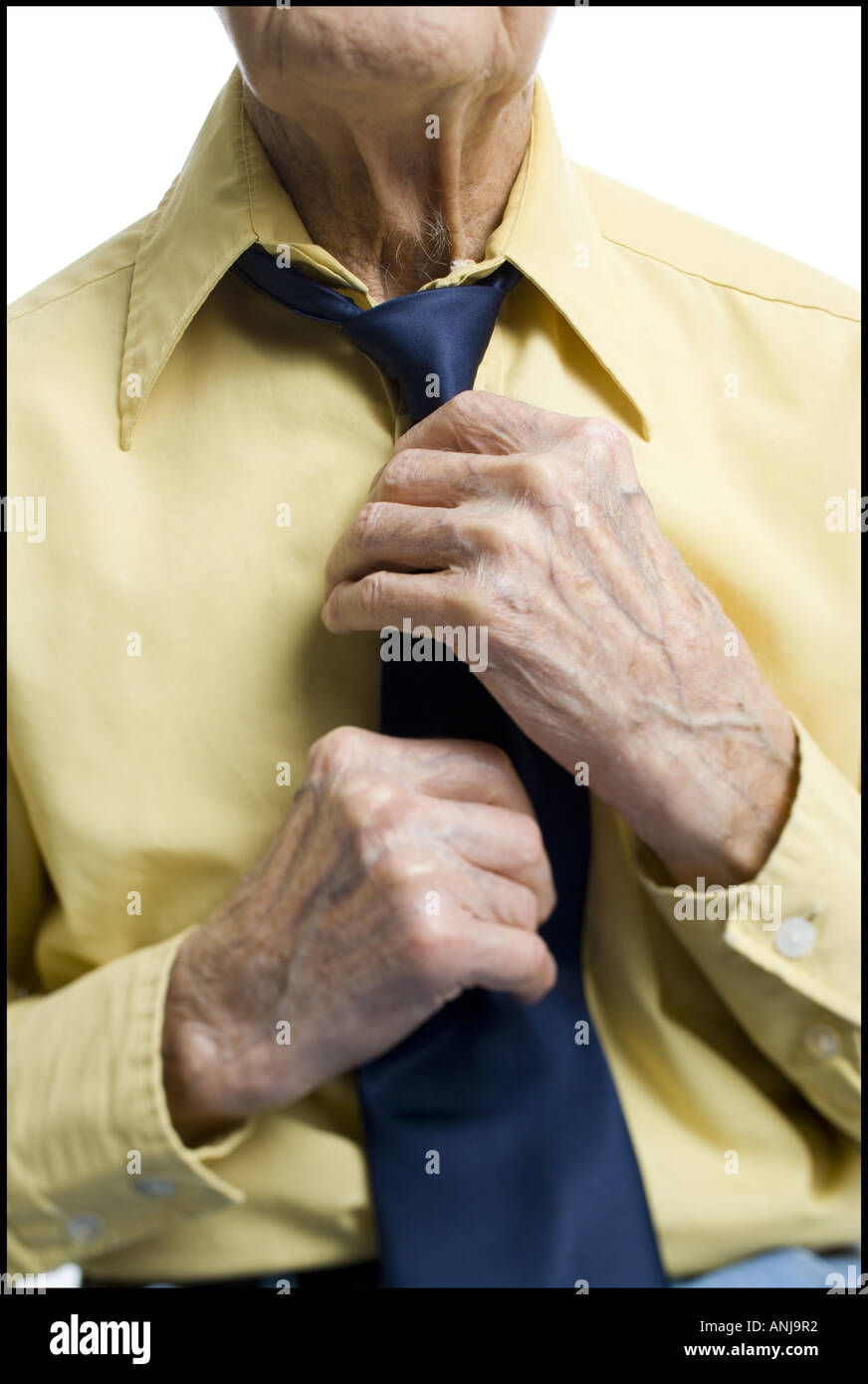 Mid section view of a senior man getting dressed Stock Photo