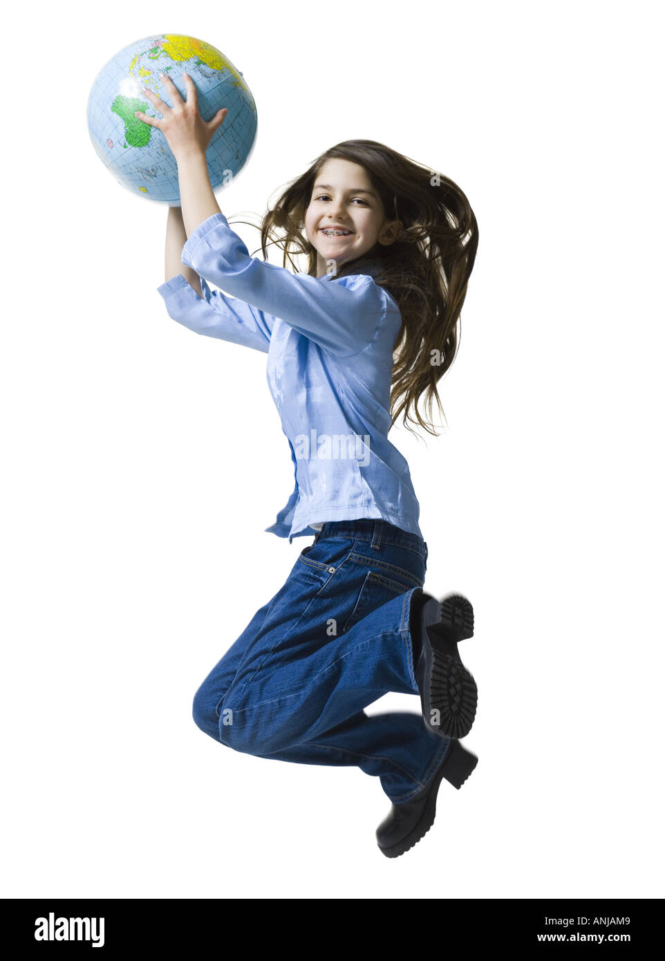 Portrait of a teenage girl jumping holding a globe Stock Photo