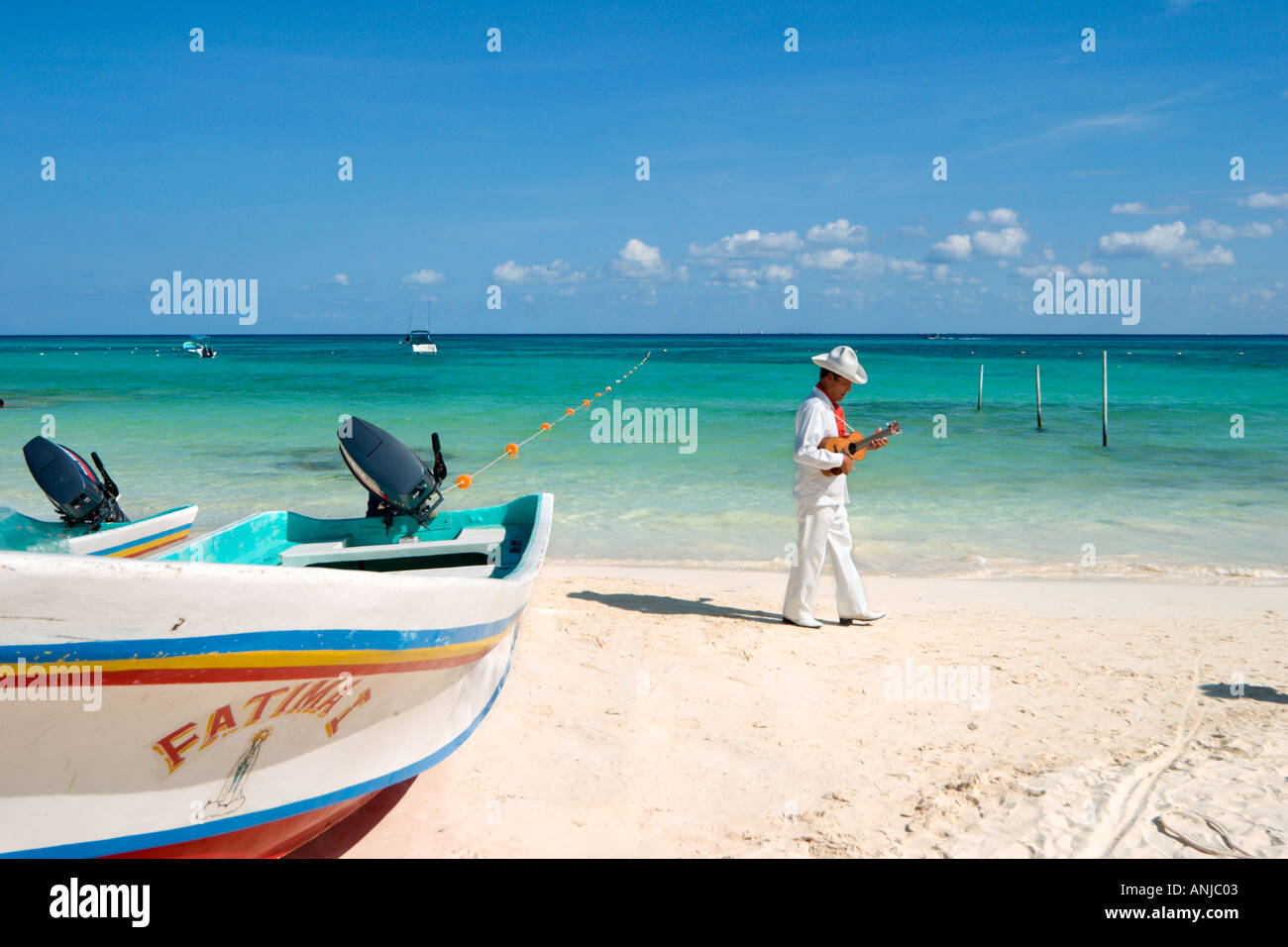 Fishing Boat and Strolling Musician on the beach in the resort centre, Playa del Carmen, Riviera Maya, Yucatan Peninsula, Mexico Stock Photo