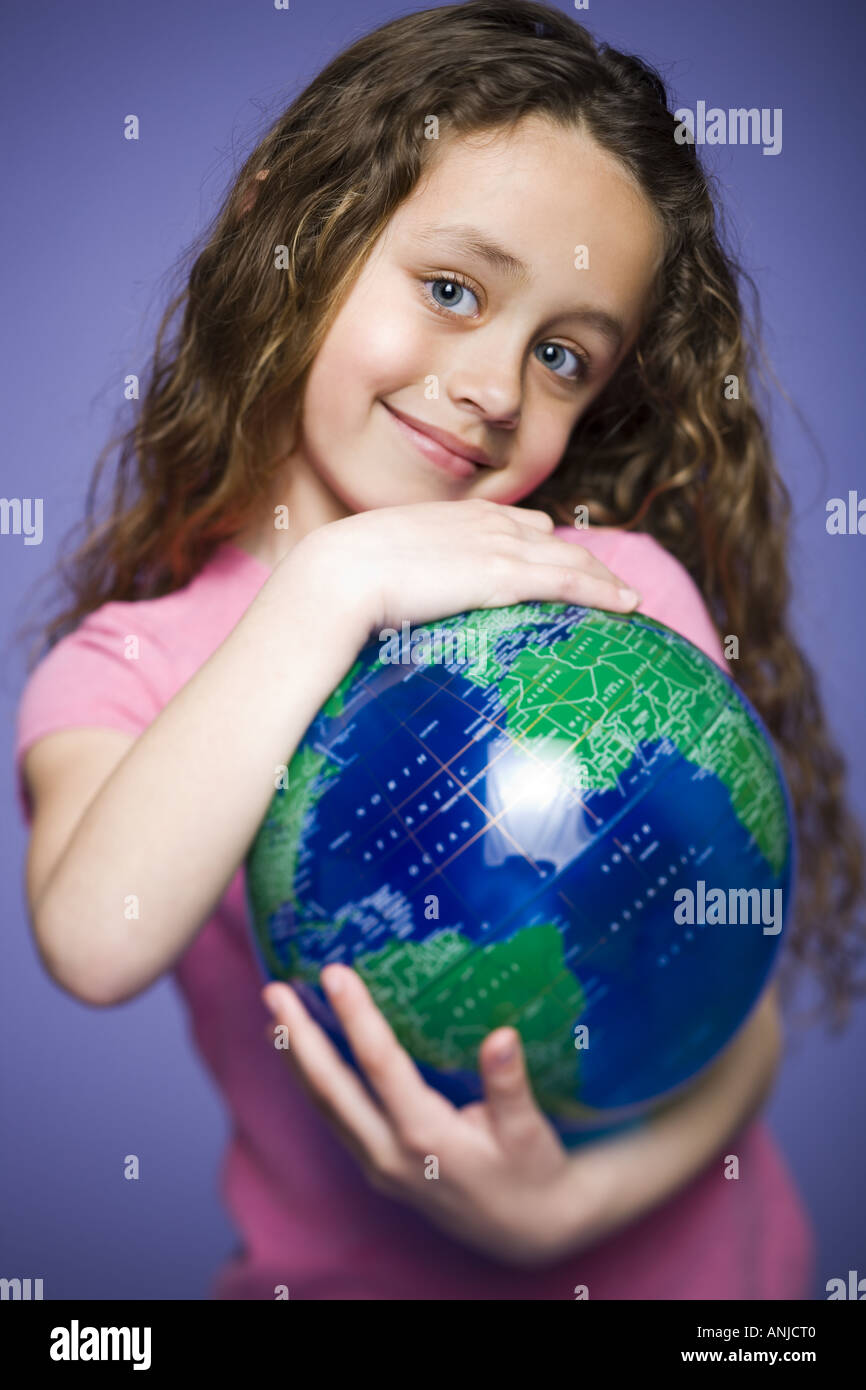 Portrait of a young girl holding a globe Stock Photo