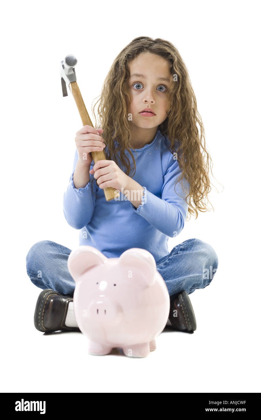 Portrait of a girl holding a hammer over a piggy bank Stock Photo