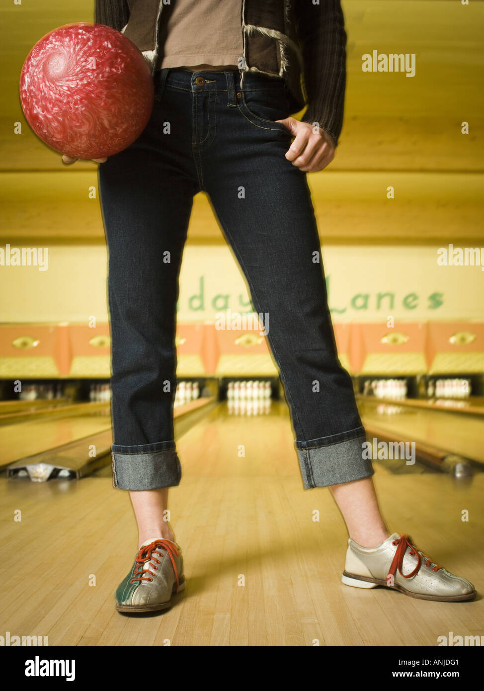 Low section view of a teenage girl standing at a bowling alley Stock Photo