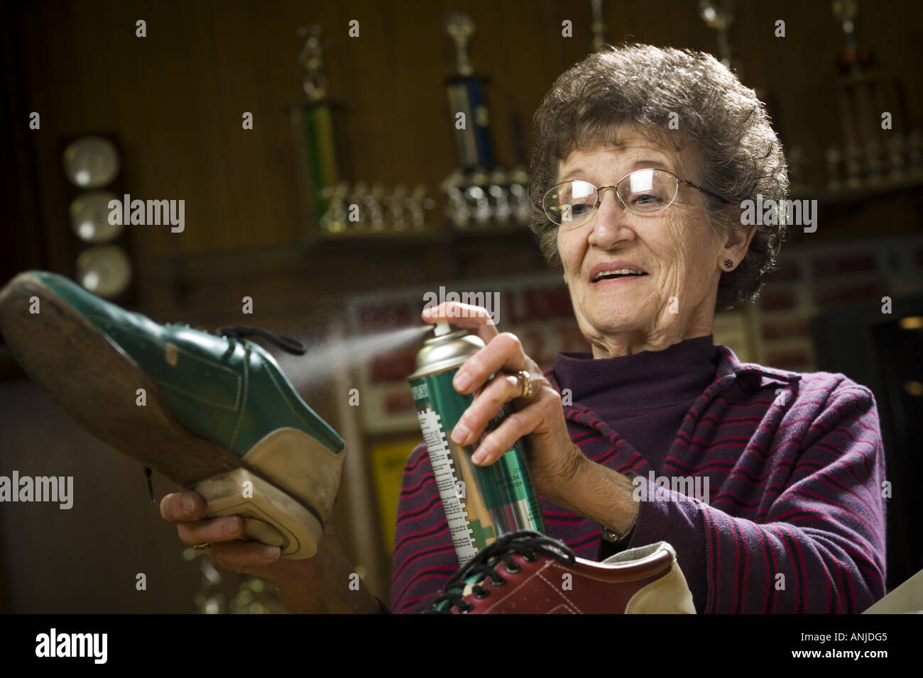 Close up of a senior woman spraying deoderant on a bowling shoe Stock Photo